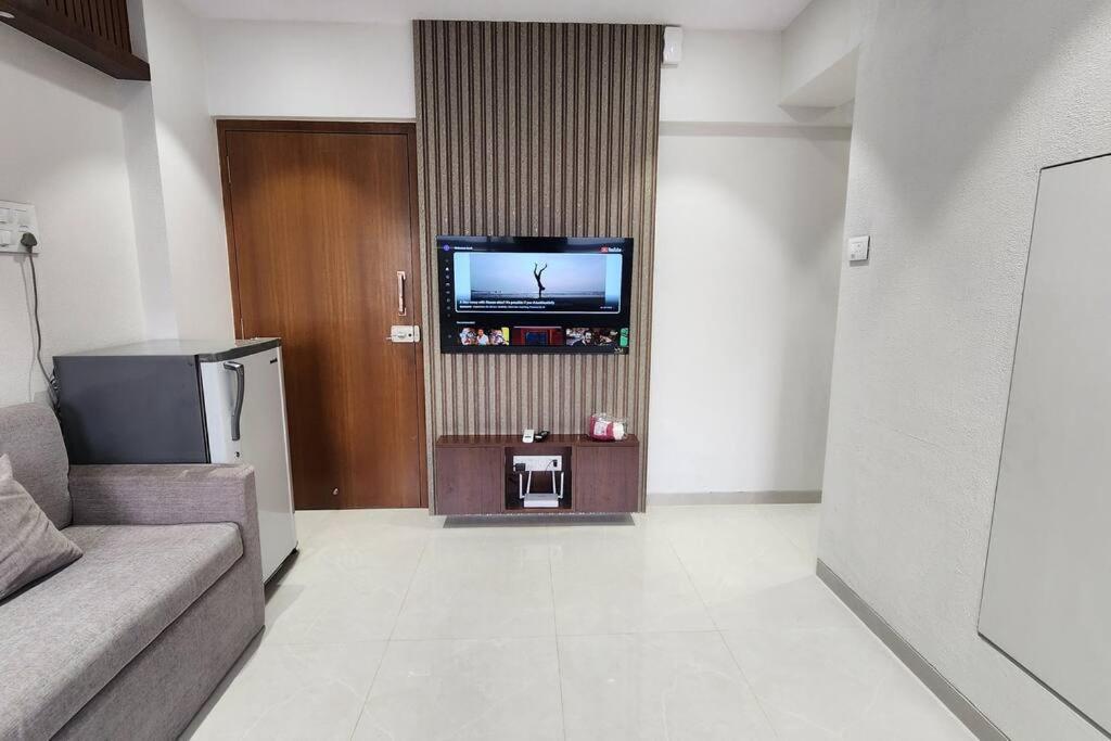 a living room with a couch and a flat screen tv at SeaScape - 1BHK - Carter Road in Mumbai