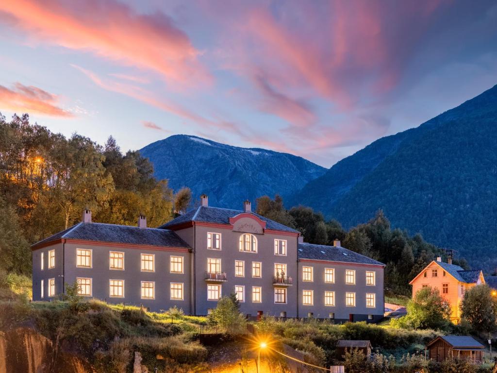 a large building with mountains in the background at Slottet Apartments in Tyssedal