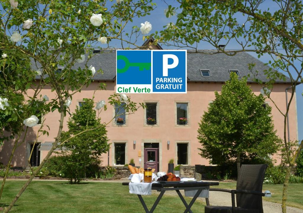un panneau de stationnement devant un bâtiment dans l'établissement HÔTEL LA FERME DE BOURRAN - écoresponsable parking gratuit, à Rodez
