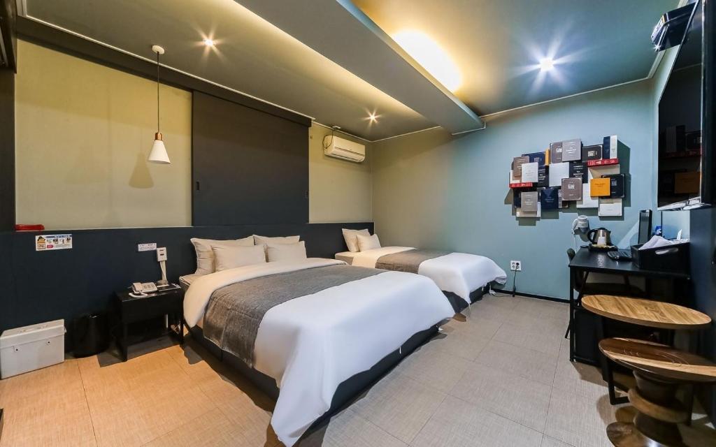a hotel room with two beds and a bar at Hi Design Hotel in Busan