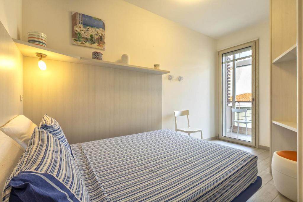 a bedroom with a bed with a blue and white striped blanket at Villafranca in Alghero