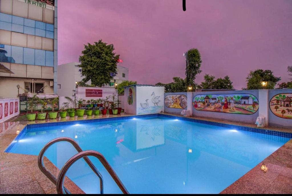 una grande piscina in un hotel di notte di The royal galaxy & Resort a Bedla