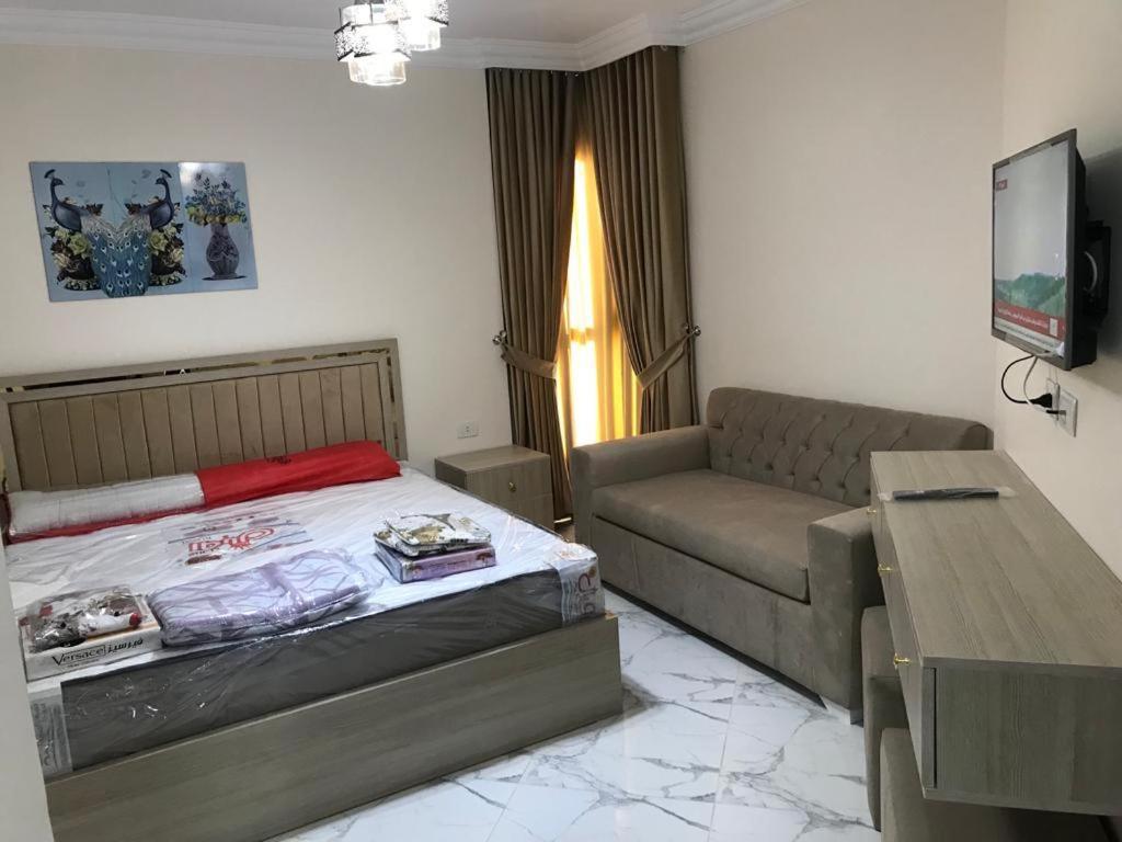 uma sala de estar com uma cama e um sofá em بورتوسعيد em `Ezbet Shalabi el-Rûdi