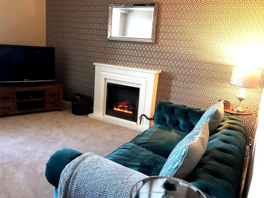 sala de estar con sofá y chimenea en Beautiful holiday flat in Alnwick en Alnwick