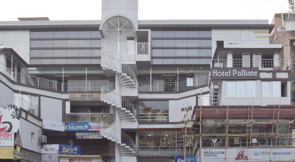 un edificio con una escalera de caracol delante de él en Hotel Palliate en Ahmedabad