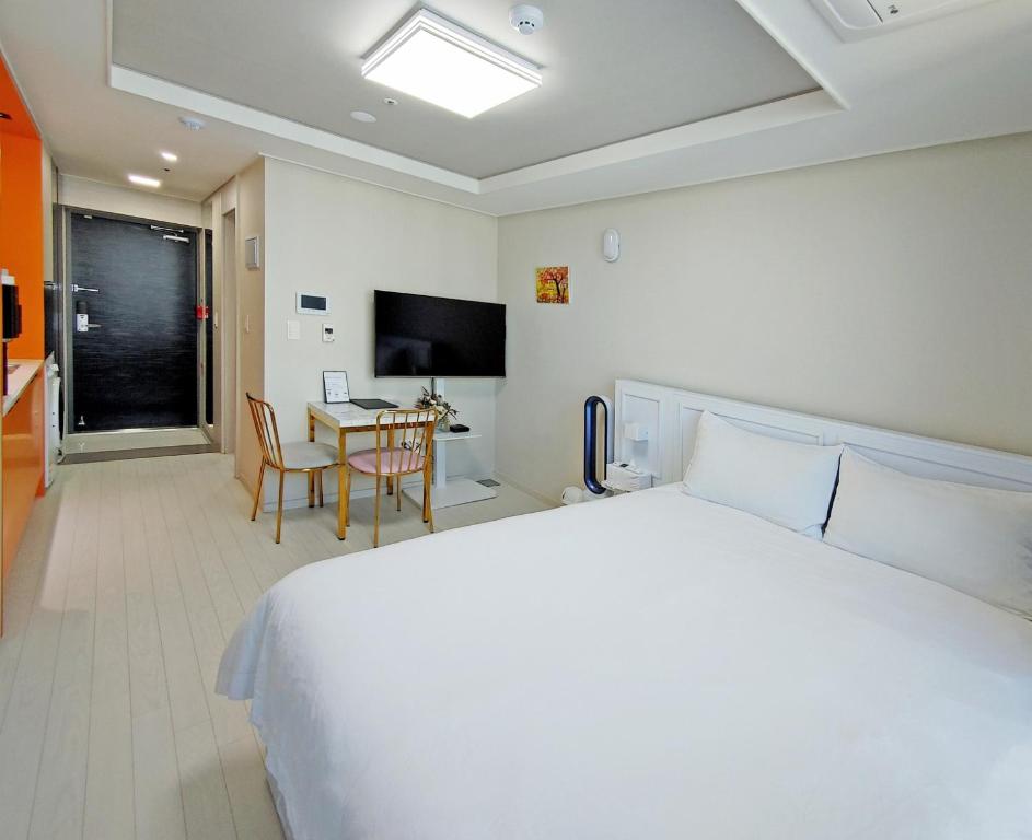 Daegu Dongseongro Star B&B business hotel في دايغو: غرفة نوم بسرير وطاولة وتلفزيون
