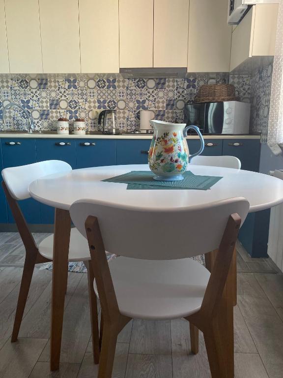 a kitchen with a white table with a vase on it at Comfortable Apartment Balakhvani in Kutaisi