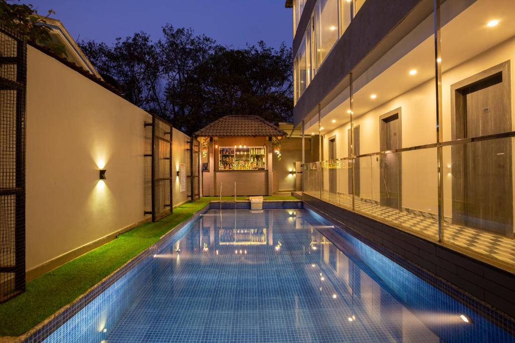 an indoor swimming pool in a house at night at The Porto by lagom , Vagator beach goa near Thalassa in Vagator