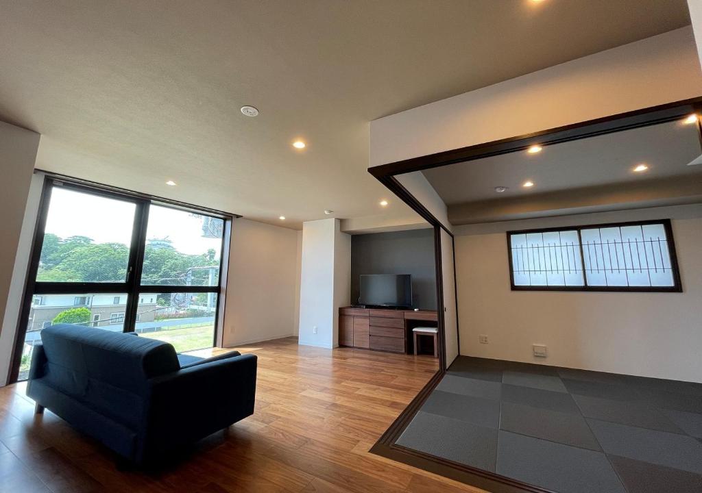 - un salon avec une chaise noire et un canapé dans l'établissement THE VIEW Odawara shiro-no mieru hotel - Vacation STAY 66140v, à Odawara