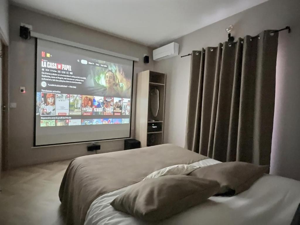 um quarto com uma cama e um ecrã de projecção em Appart Hotel Cinéma Perpignan em Perpignan