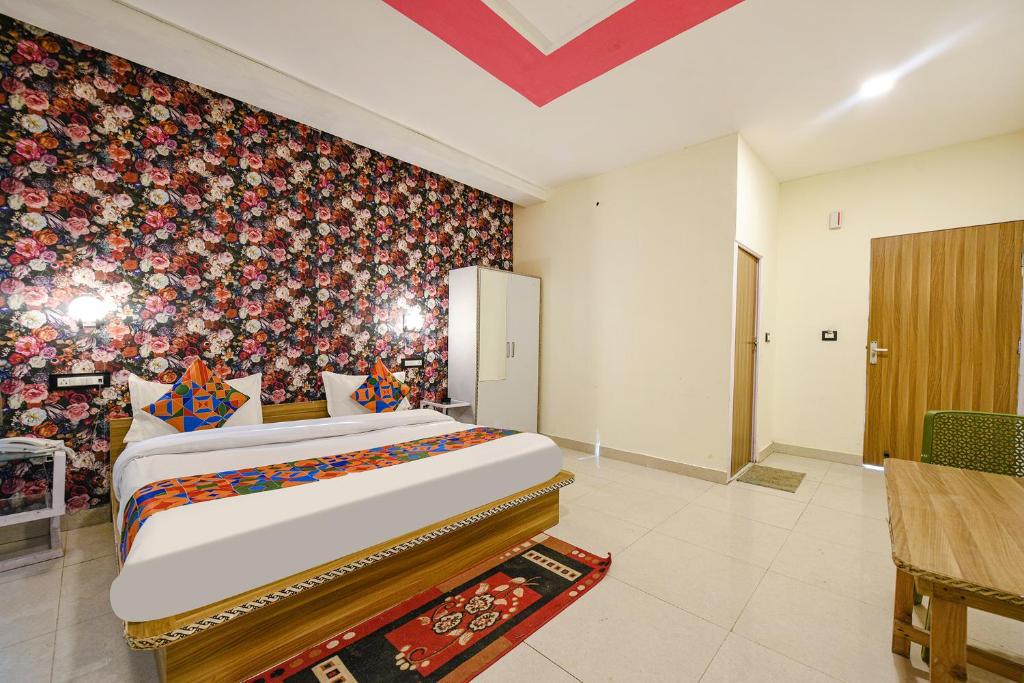 a bedroom with a large bed with a floral wall at FabHotel Sizzling Resort & Adventure in Dhanaulti