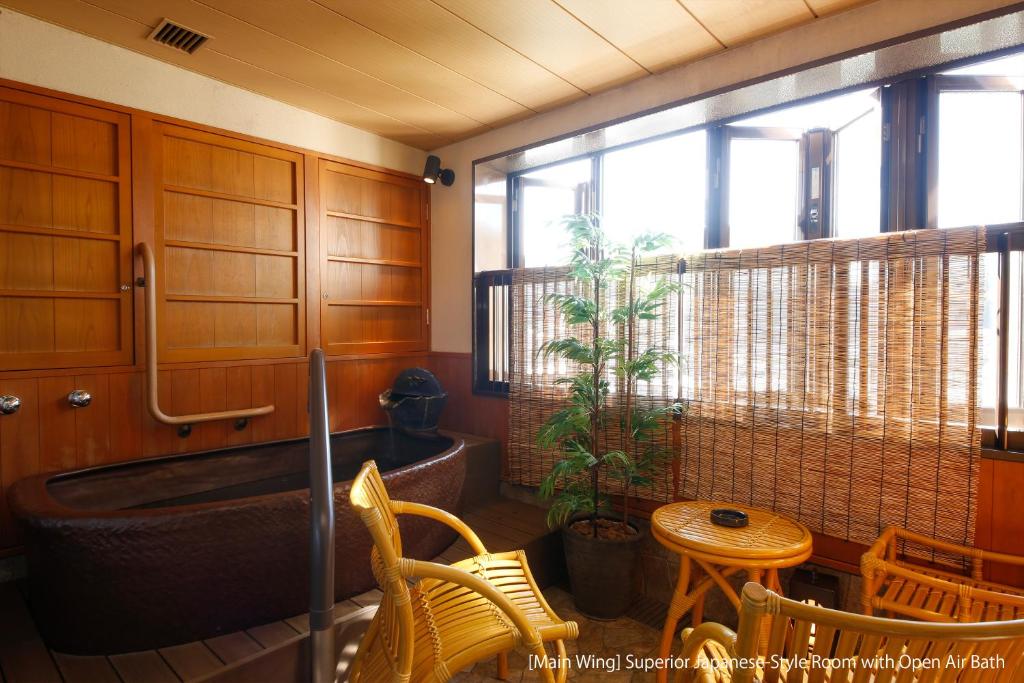 a bathroom with a tub and a table and chairs at Hida Takayama Onsen Takayama Green Hotel - KEIO GROUP HOTELS - in Takayama