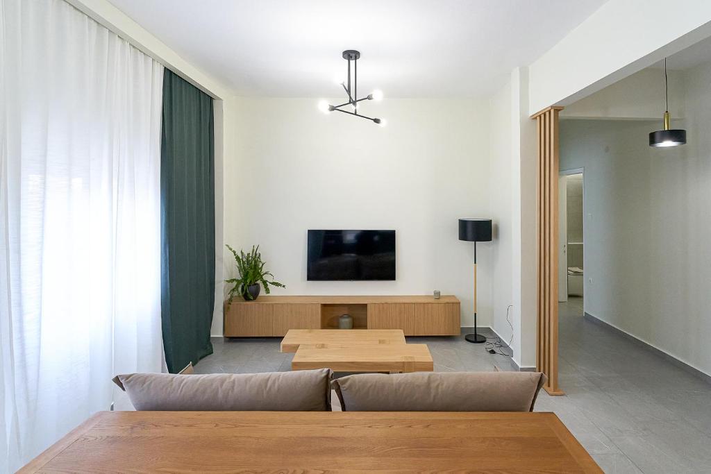 sala de estar con sofá y TV en INOHO Fern Apartment, en Xanthi