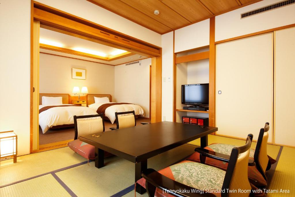 a room with a dining table and a bedroom at Hida Takayama Onsen Takayama Green Hotel - KEIO GROUP HOTELS - in Takayama