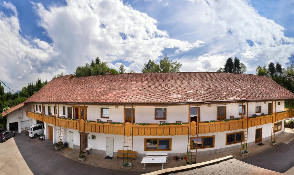 ein großes weißes Gebäude mit braunem Dach in der Unterkunft Gästehaus Lanthaler in Rosenbach