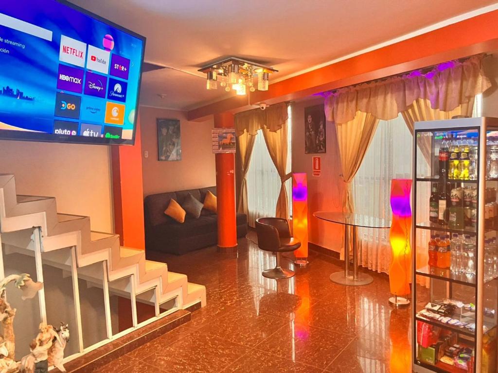 sala de estar con TV grande y bar en Hostal El Rancho, en Huancayo