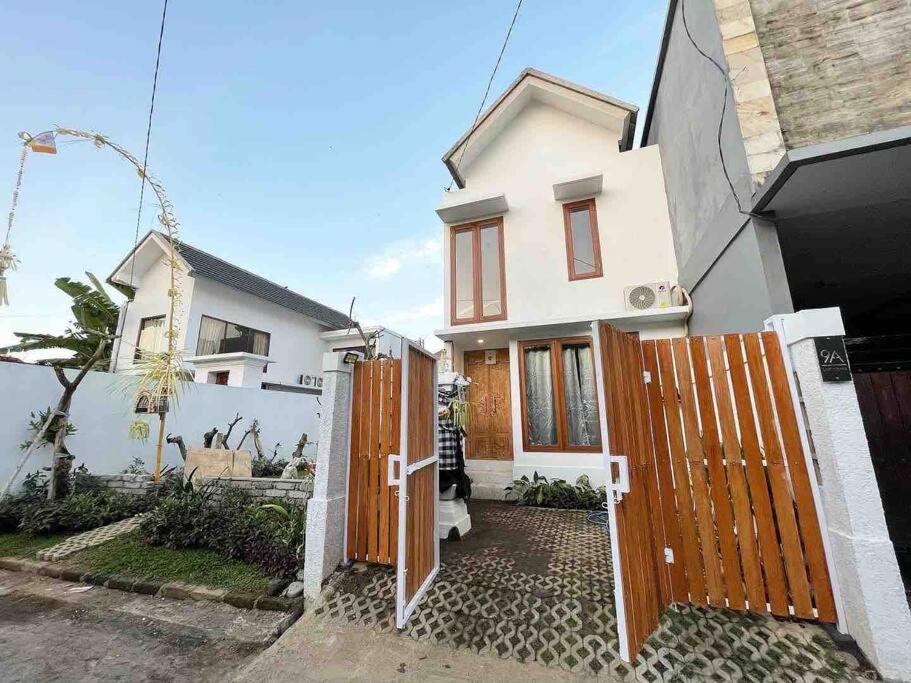una casa blanca con una puerta de madera delante de ella en LaKalena Private Villa Bali, en Ketewel