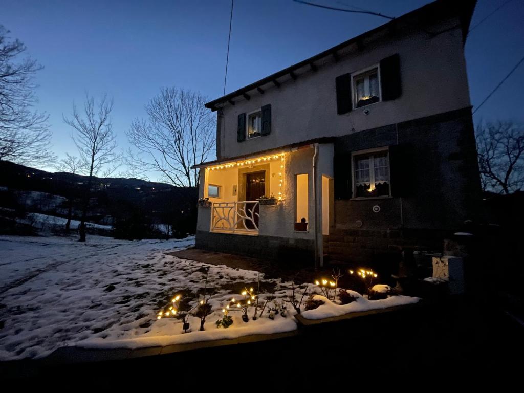 a house with lights in front of it in the snow at Cà di Lucca in Lizzano in Belvedere