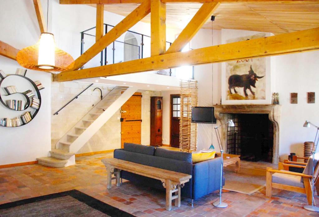 - un salon avec un canapé bleu et un escalier dans l'établissement Les Tourelles, à Uzès