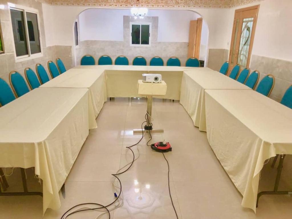 a conference room with tables and chairs and a camera on the floor at kaizen Restaurant Nouakchott in Nouakchott