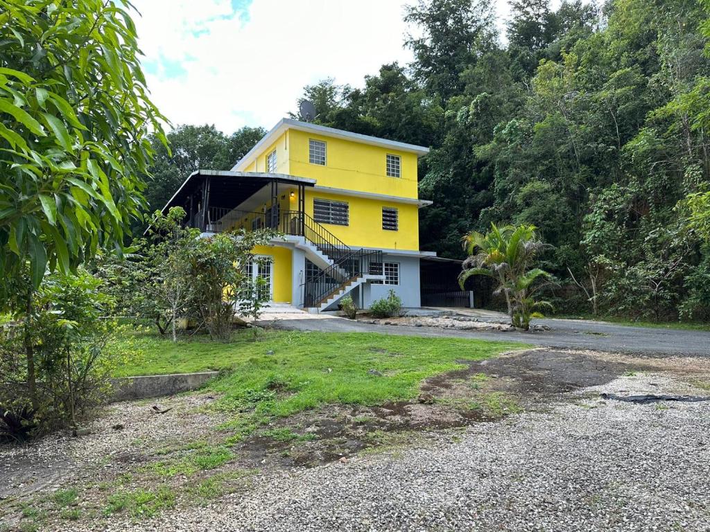 a yellow house in the middle of a yard at Near Beach, Rivers, Lagoon, Spring, Sleep up to 22, 2nd Floor in Vega Baja