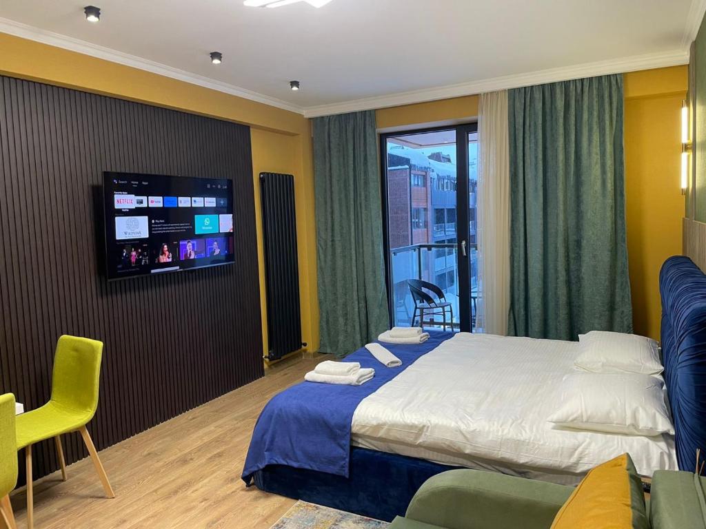 Una habitación de hotel con una cama y un televisor de pantalla plana. en Brand new apartment near Gondola, en Gudauri