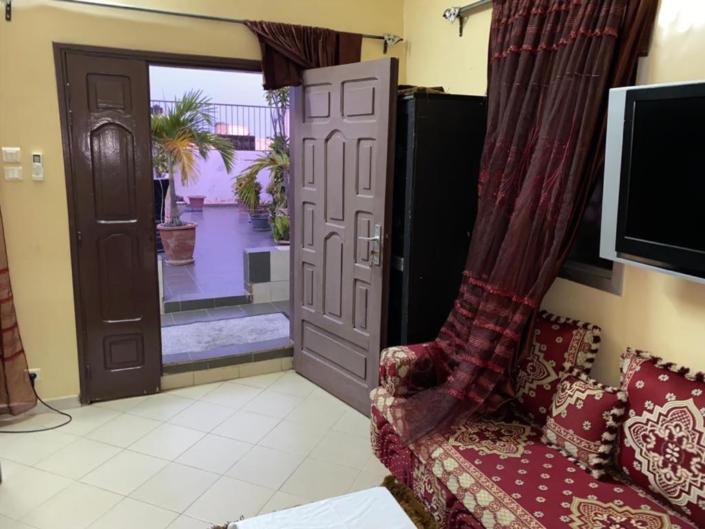 uma sala de estar com um sofá e uma porta em Appartement Ngor Almadie em Dakar