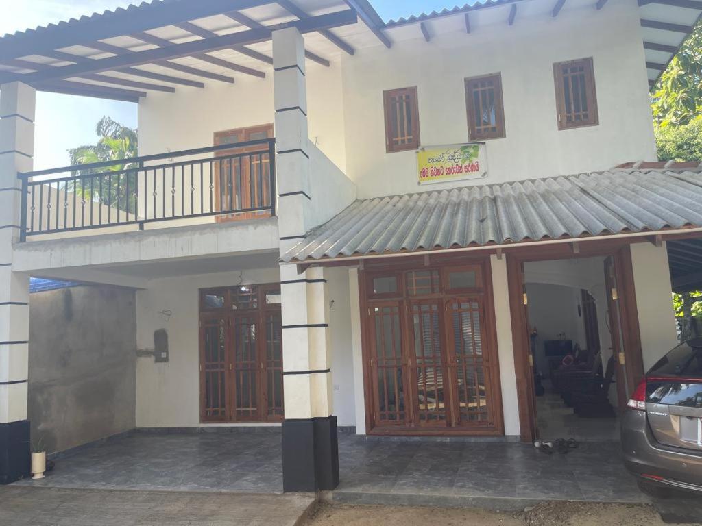 Casa con puertas de madera y balcón. en Shenumi villa en Waskaduwa