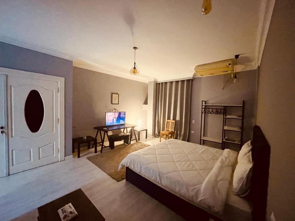 Schlafzimmer mit einem Bett und einem Schreibtisch mit einem TV in der Unterkunft Rove Residence New Cairo in Kairo