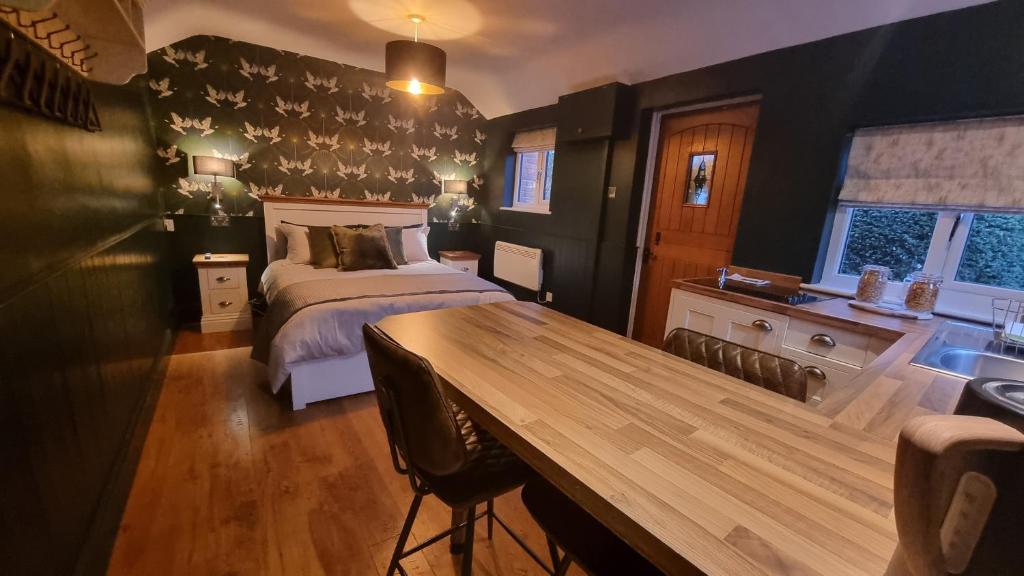 sypialnia z łóżkiem i drewnianym stołem w obiekcie Bijou Malthouse w mieście Alcester
