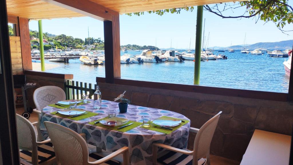 un tavolo in un ristorante con vista su un porto turistico di Maison de pêcheur à Giens les pieds dans l'eau ! a Hyères
