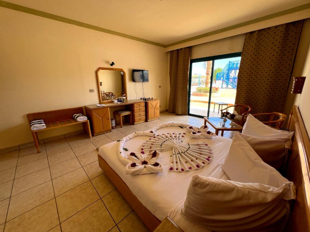 Sharm Cliff Hotel في شرم الشيخ: غرفة نوم بسرير كبير مع مرآة كبيرة