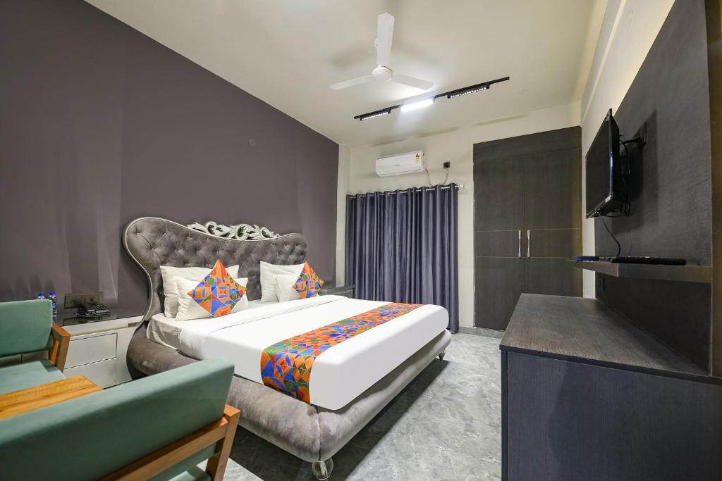 1 dormitorio con cama, sofá y TV en FabHotel Naina Residency en Rāiwāla