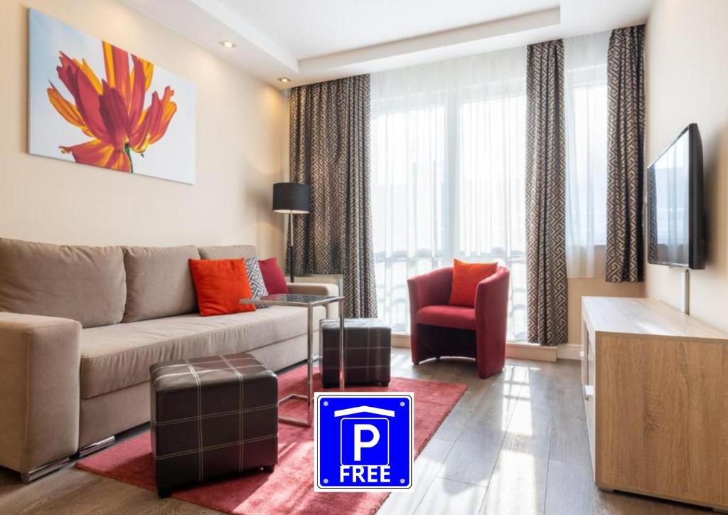 uma sala de estar com um sofá e uma televisão em Silver Crown Hotel & Residence, Palace Quarter em Budapeste