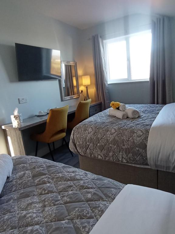 a hotel room with two beds and a desk at Tiernan's luxury triple room Ensuite in Newtown-Dillon