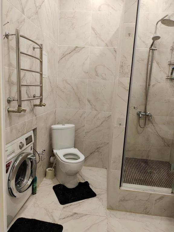 een badkamer met een toilet en een douche bij Сдаётся 2х комн кв в центре города ЖК Астана in Aqtau