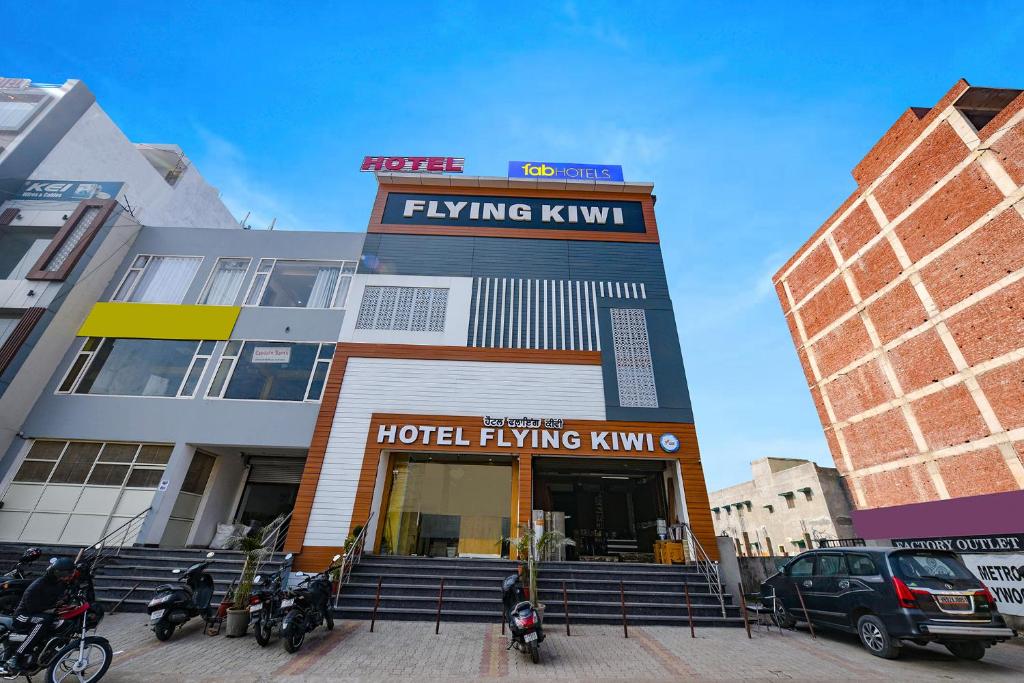 um edifício de hotel com motos estacionadas em frente em FabHotel Flying Kiwi em Mohali