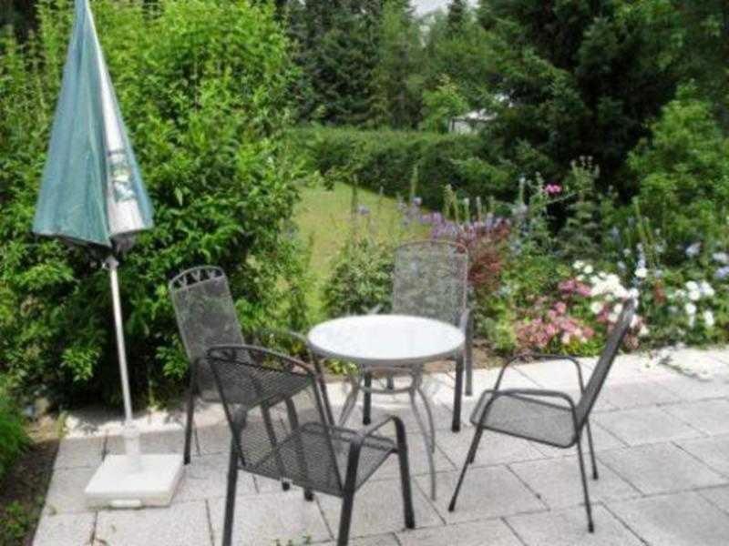 una mesa, sillas y una sombrilla en el patio en Doppelhaushälfte in idyllischer Lage, separater Eingang en Reimershagen