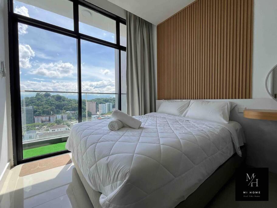 a bedroom with a large bed with a large window at The Shore Kota Kinabalu by MiHome in Kota Kinabalu