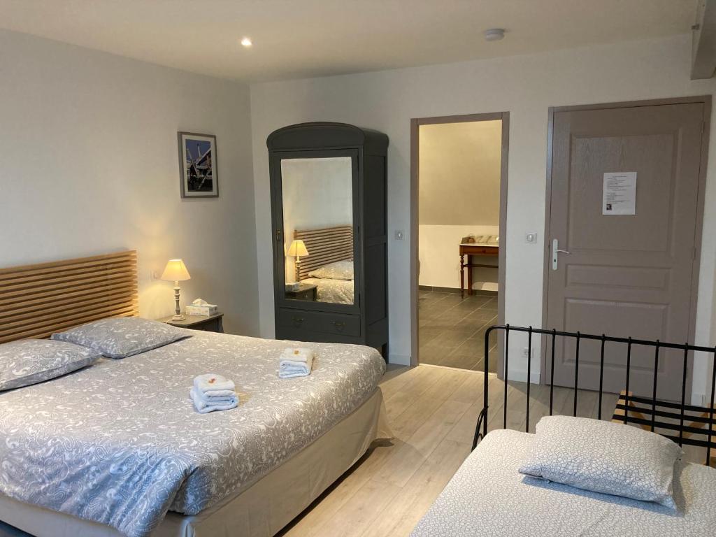 a bedroom with two beds and a large mirror at Chambres d'hotes Maison Gille in Nuits-Saint-Georges