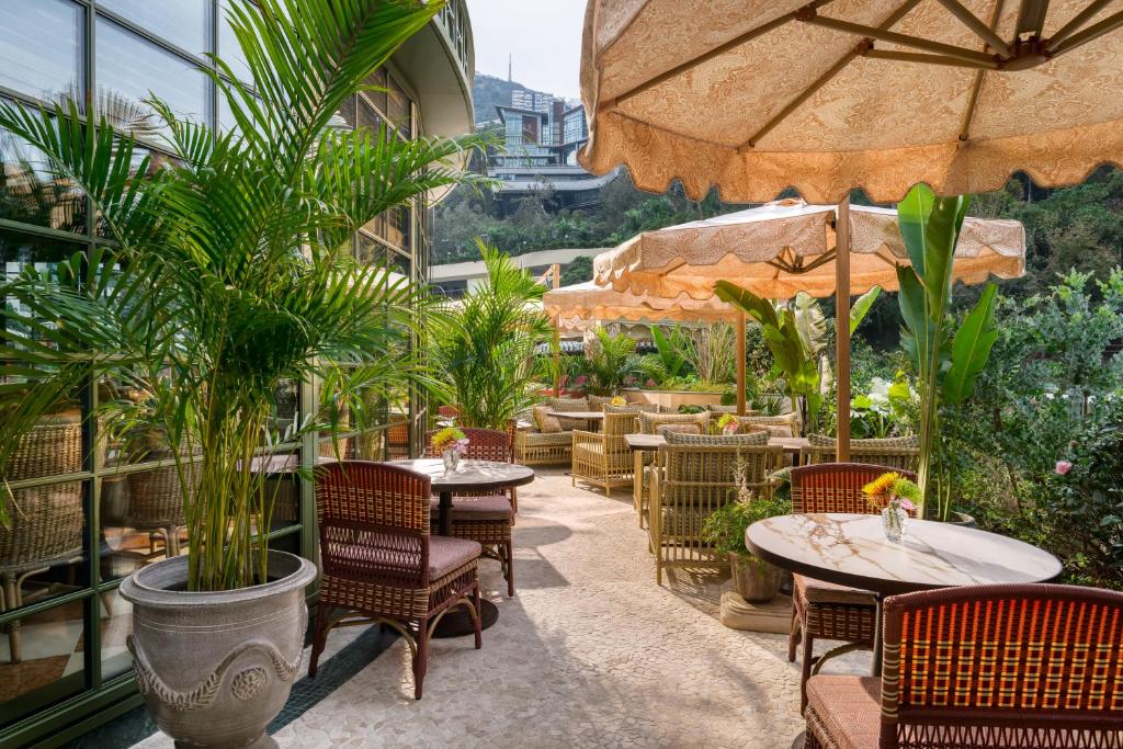 an outdoor patio with tables and chairs and plants at Island Shangri-La, Hong Kong in Hong Kong