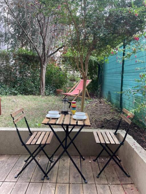 - une table de pique-nique et 2 chaises sur la terrasse dans l'établissement Charmant T2 avec Jardin, à Paris