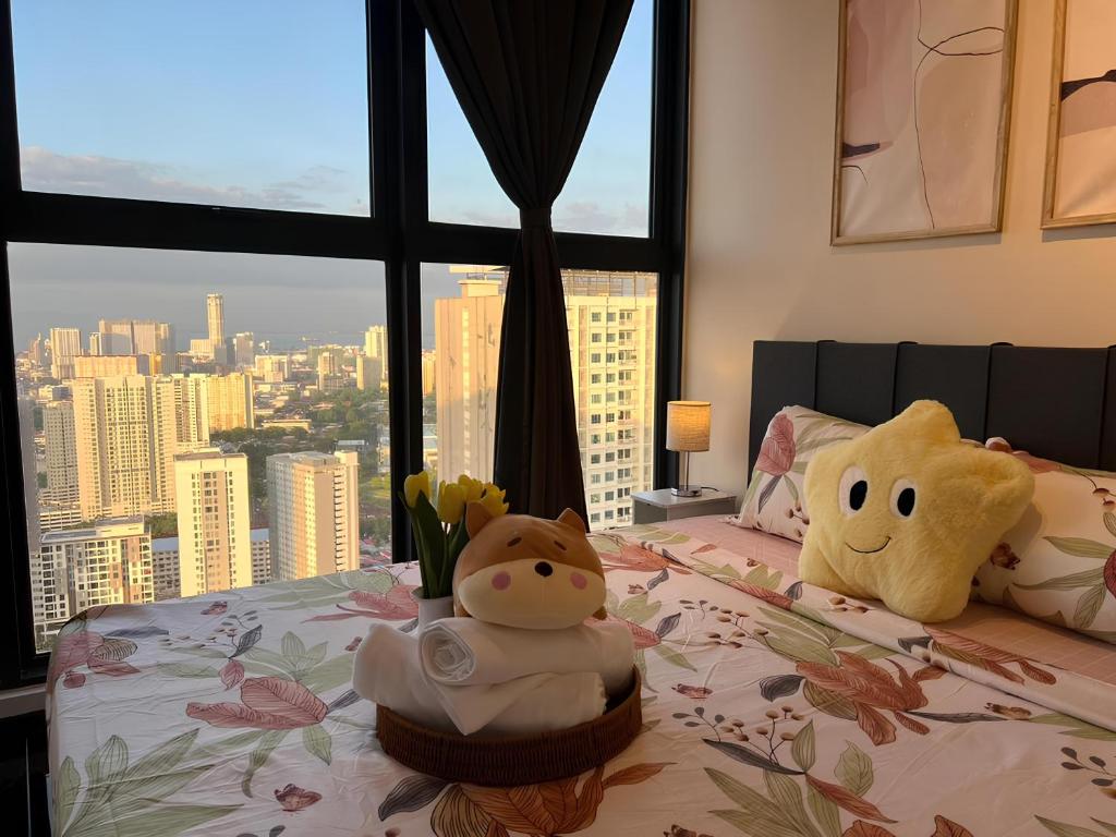 una cama con dos animales de peluche con una ventana en Urban Suites by PerfectSweetHome with Spectacular High View# Komtar View, en Jelutong