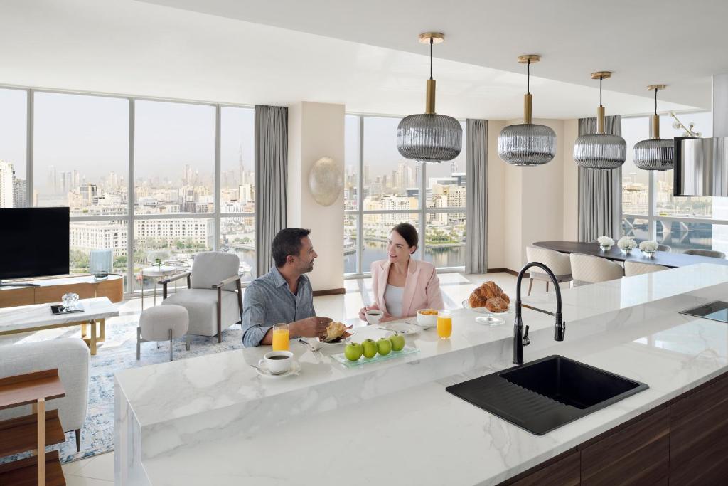 a man and a woman sitting in a kitchen at InterContinental Residence Suites Dubai Festival City, an IHG Hotel in Dubai