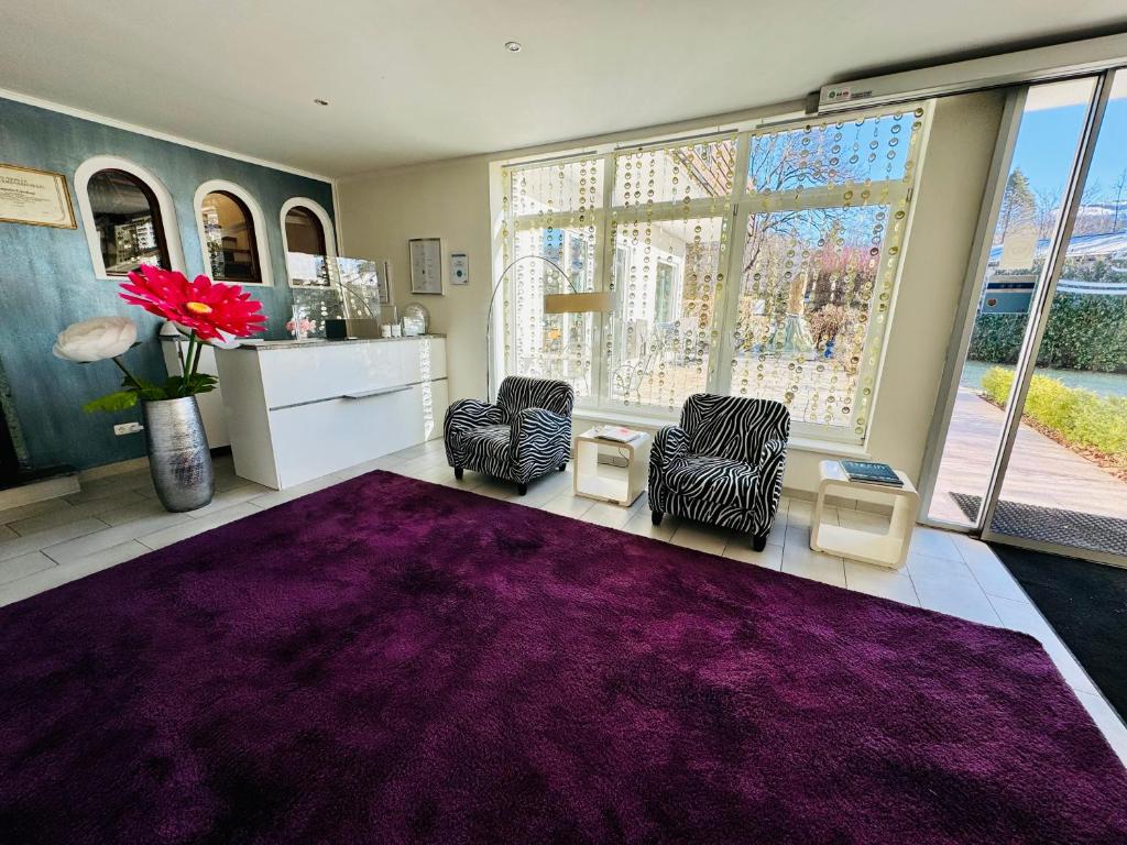 a room with two chairs and a purple rug at Hotel Oase in Bad Ischl