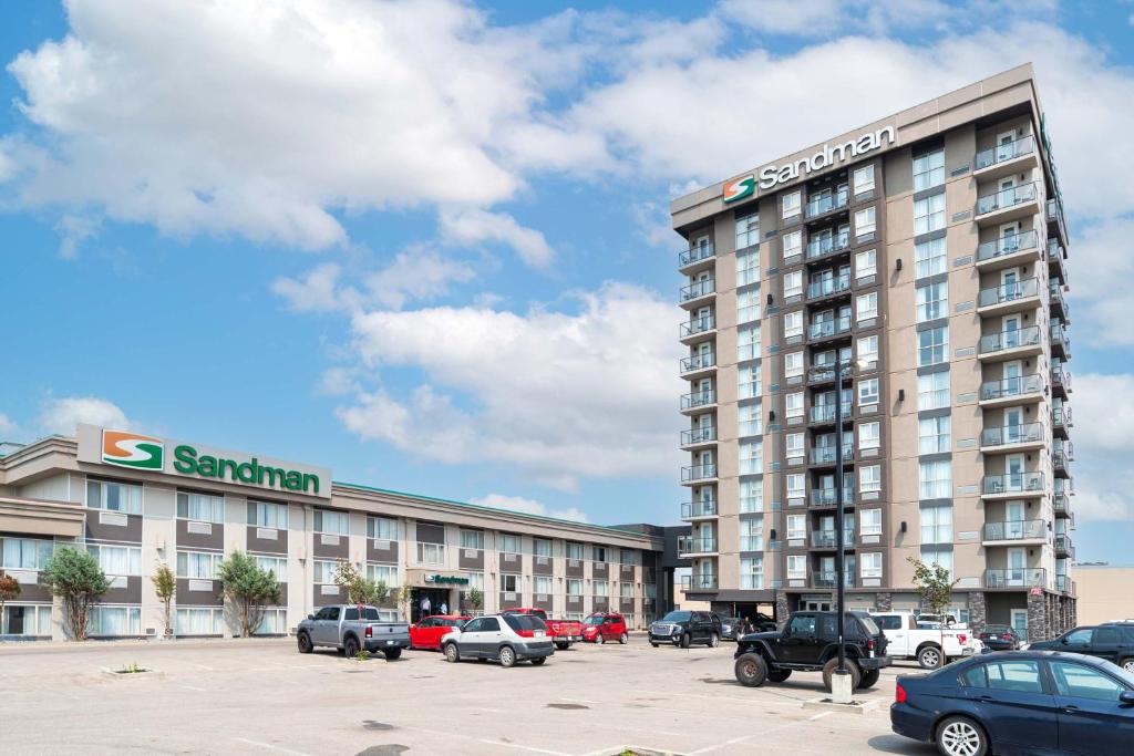 um grande edifício com carros estacionados num parque de estacionamento em Sandman Hotel Edmonton West em Edmonton