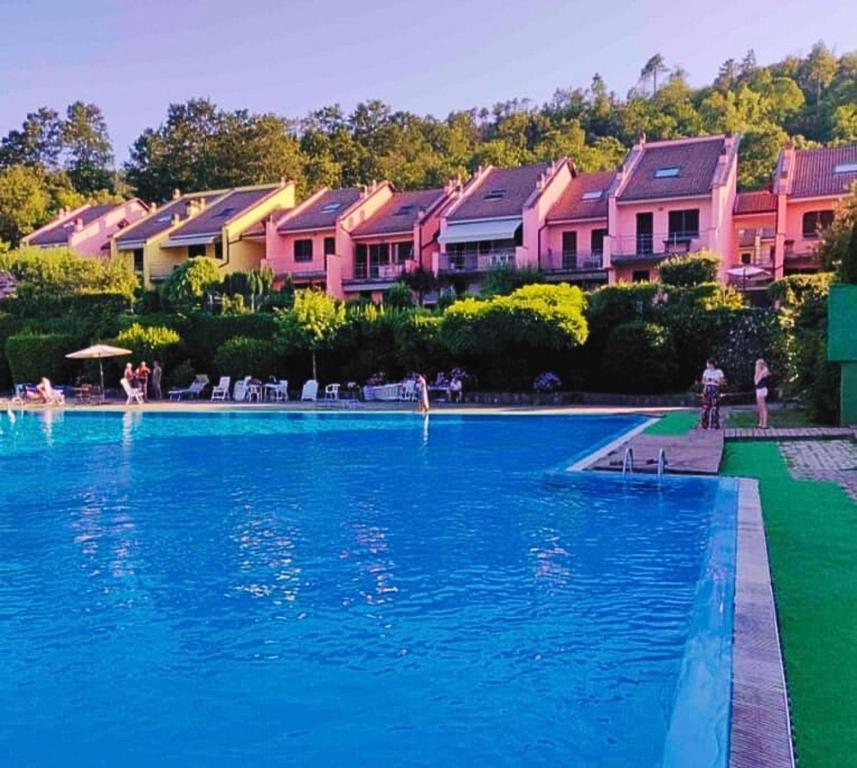 a swimming pool in front of some pink houses at Casa vacanze alle Cinque Terre in Soviore
