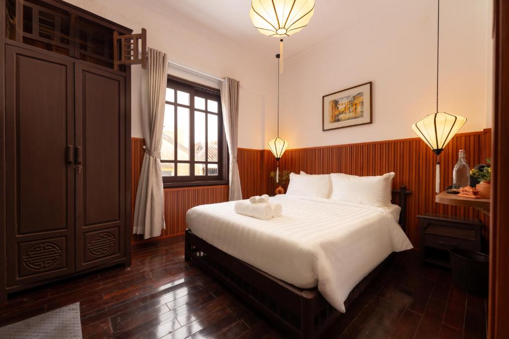 Postel nebo postele na pokoji v ubytování Hoianese Heritage Hotel - Truly Hoi An