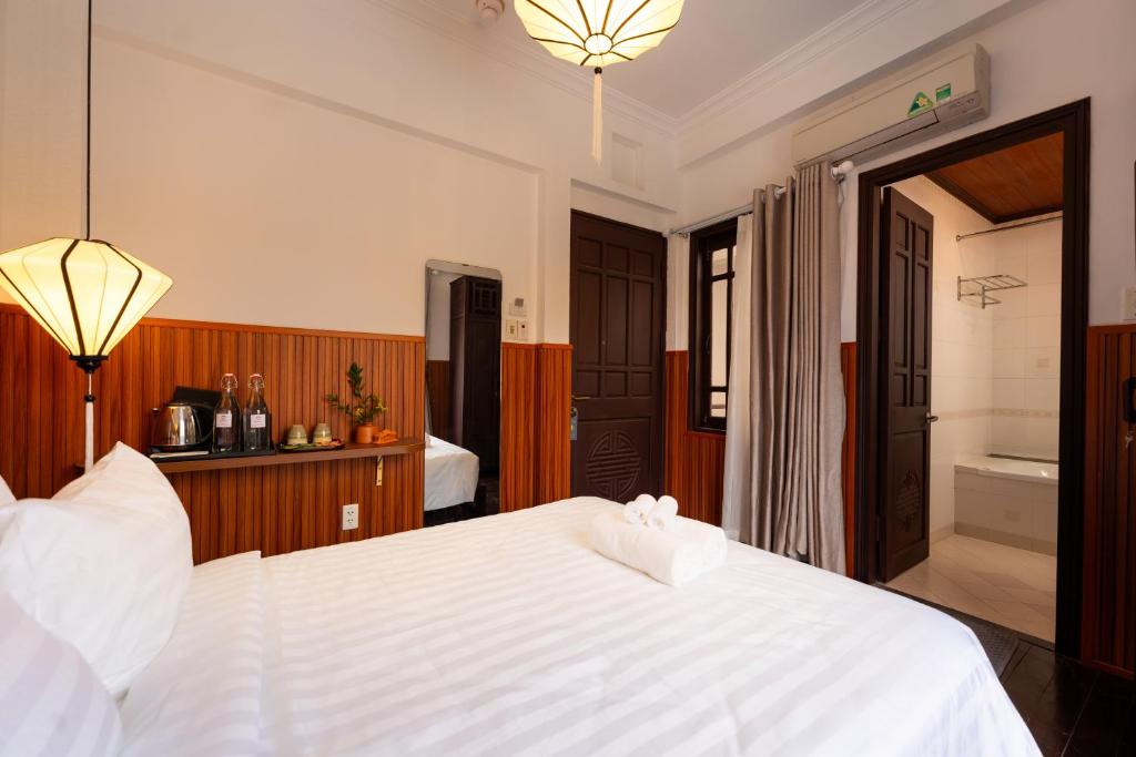 Postel nebo postele na pokoji v ubytování Hoianese Heritage Hotel - Truly Hoi An