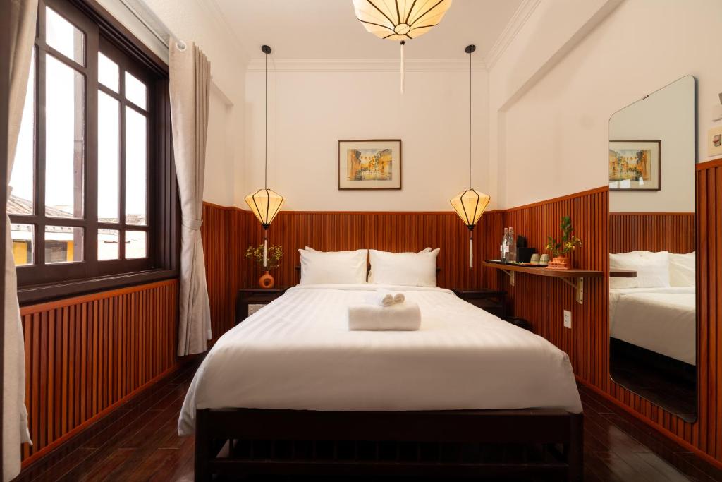 Postel nebo postele na pokoji v ubytování Hoianese Heritage Hotel - Truly Hoi An